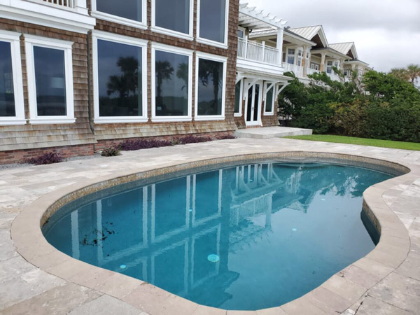 Beautifully remodeled residential pool glowing under the evening sky in Jacksonville, FL.